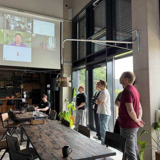 Morning standup with remote participants joining on the big screen